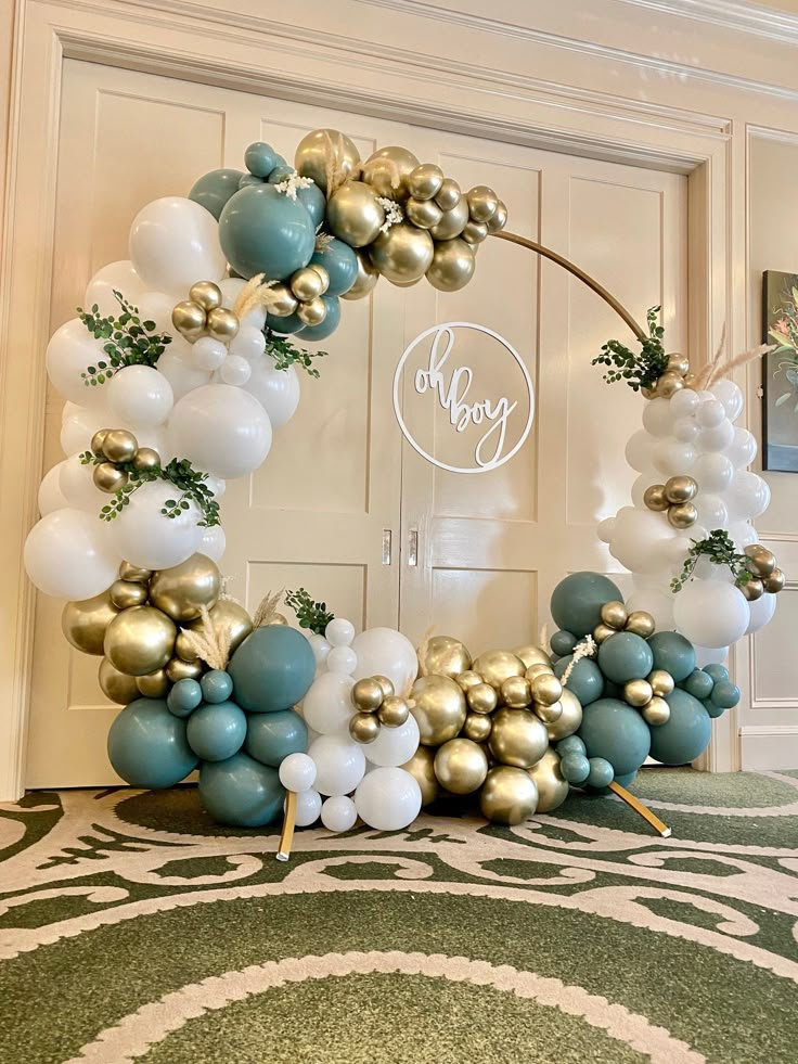 the balloon arch is decorated with gold, white and blue balloons