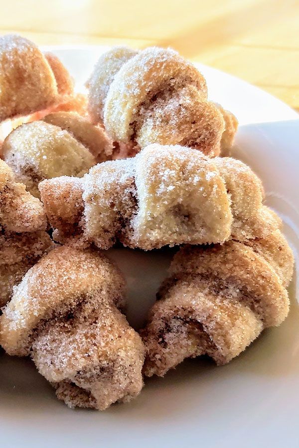 a white plate topped with sugar covered donuts