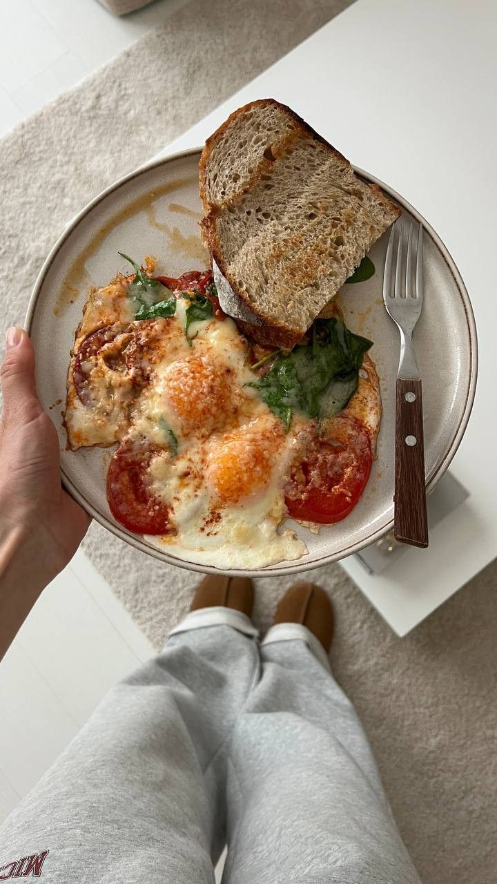 a person holding a plate with food on it and a fork in front of them