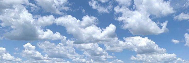 the sky is filled with fluffy clouds and blue water