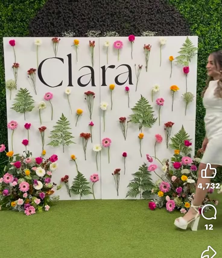 a woman standing in front of a floral display