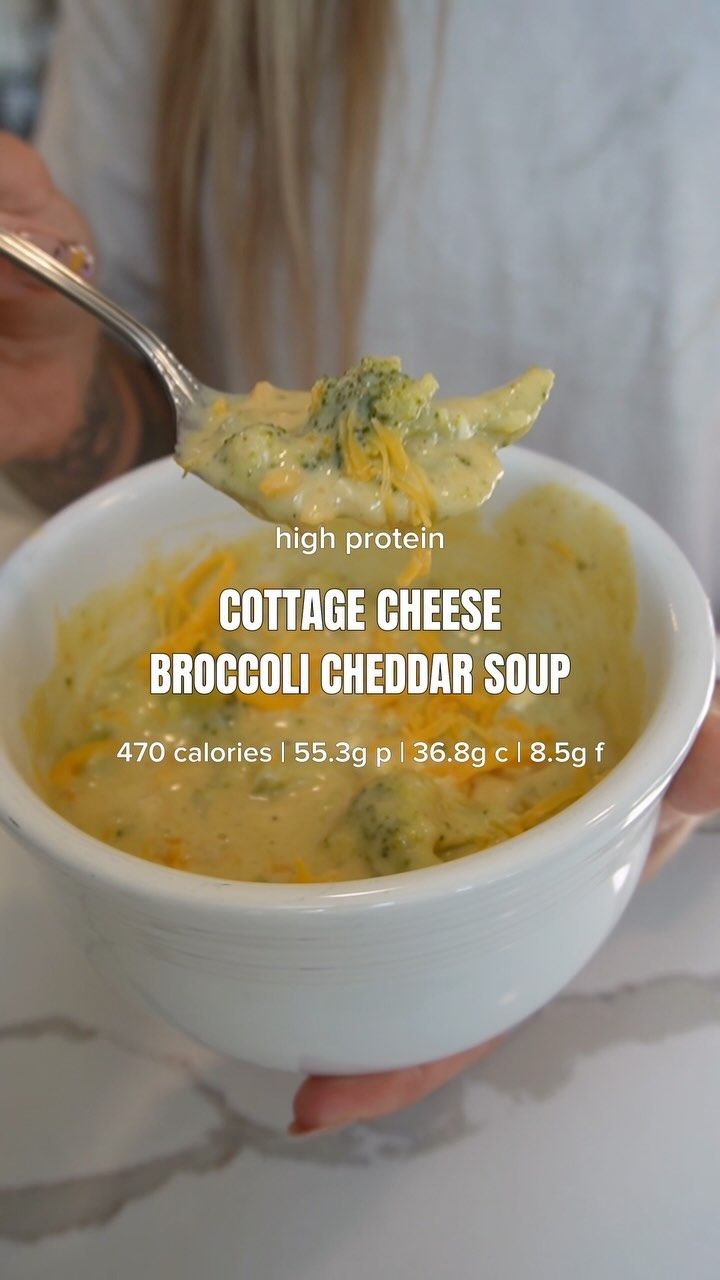 the broccoli cheddar soup is in a white bowl with a spoon