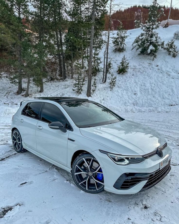 a white car is parked in the snow