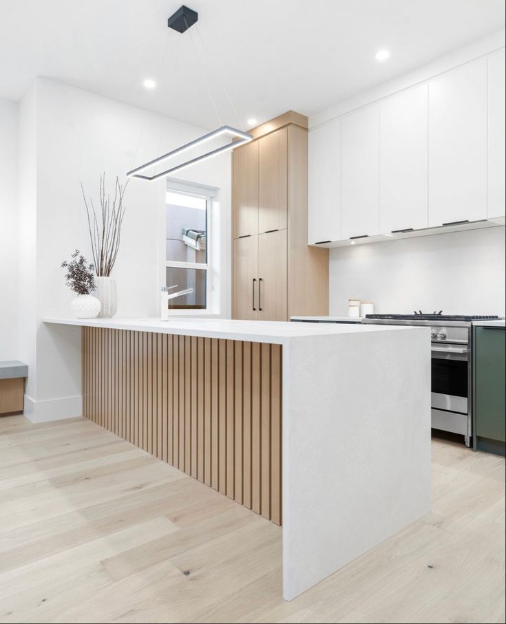 a kitchen with white cabinets and wooden counter tops, along with an island in the middle