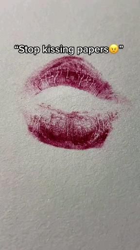 a close up of a red lipstick with the words stop kissing papers