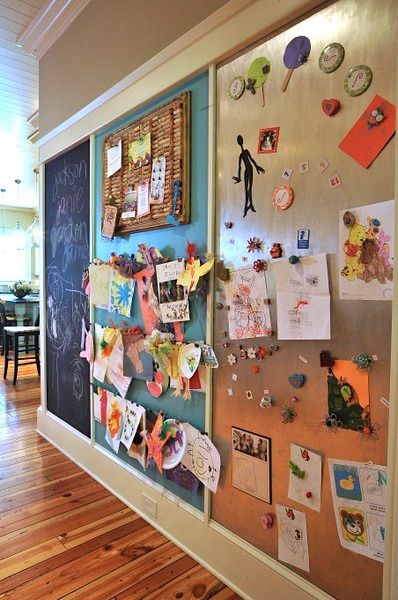 a bulletin board with pictures and magnets on it in an office hallway or playroom