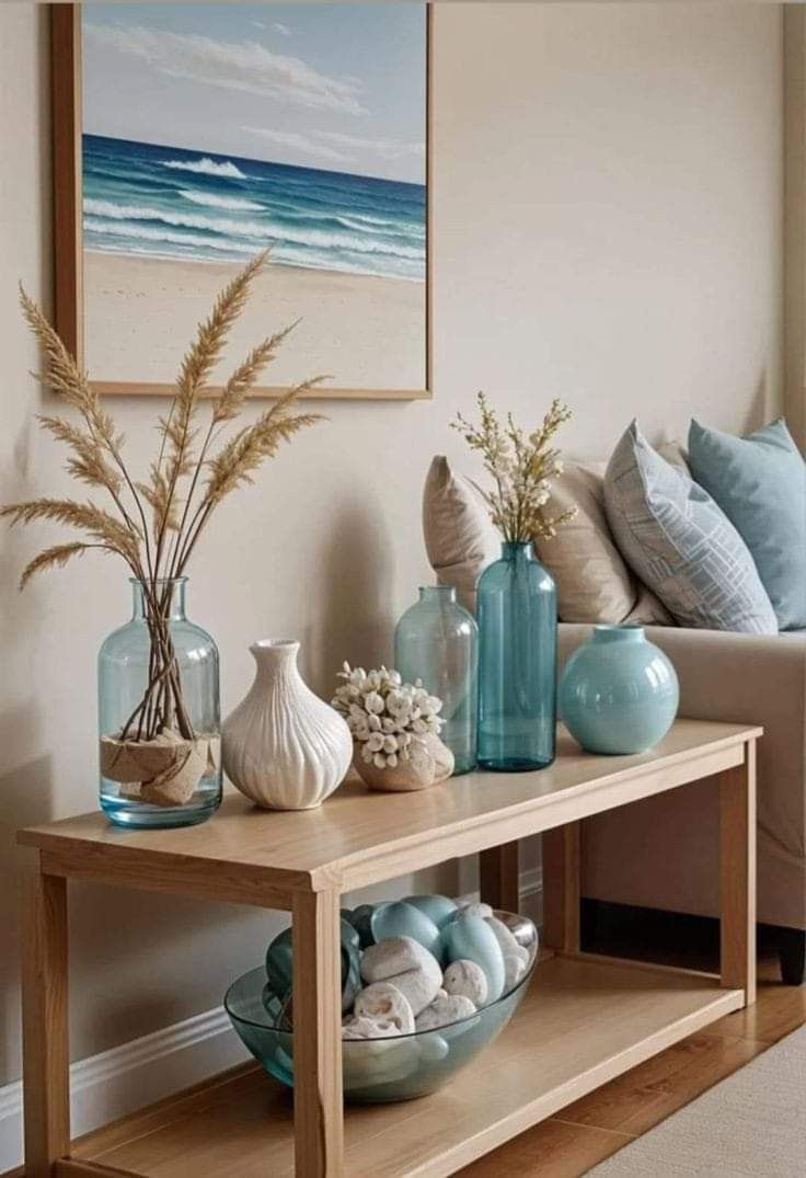 a table with vases and seashells on it in front of a couch