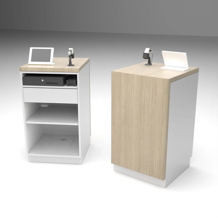 two electronic devices sitting on top of a wooden stand next to each other in front of a white background