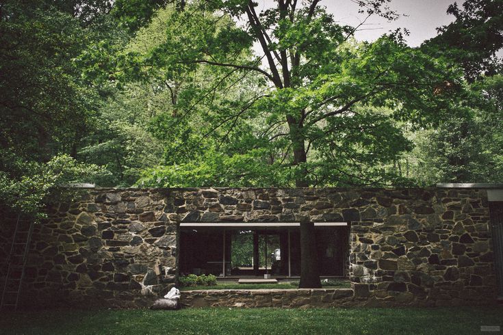 a stone house with trees in the background