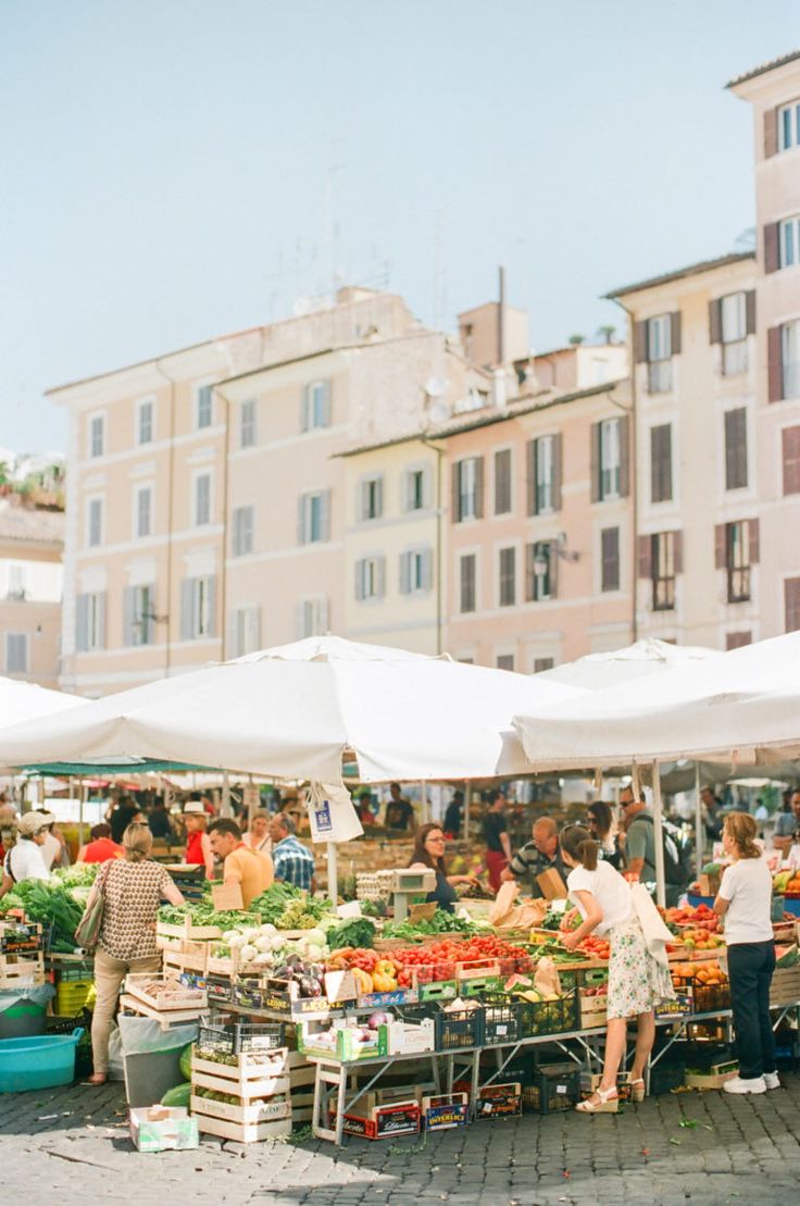 people shopping at an open air market in the city