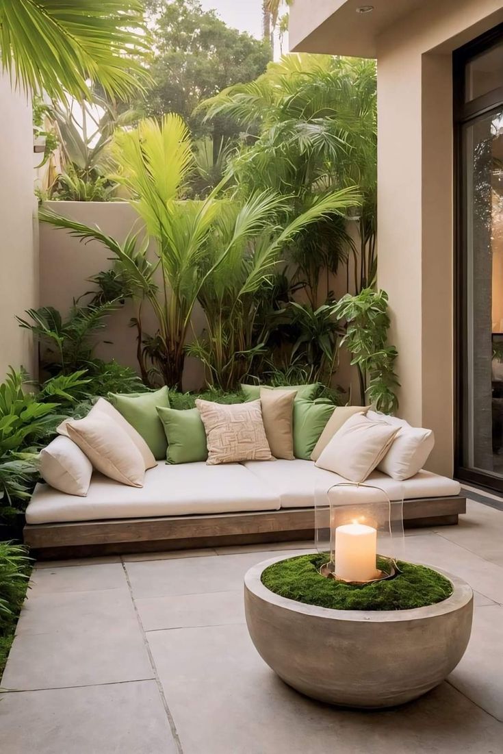 a couch sitting on top of a stone floor next to a lush green plant