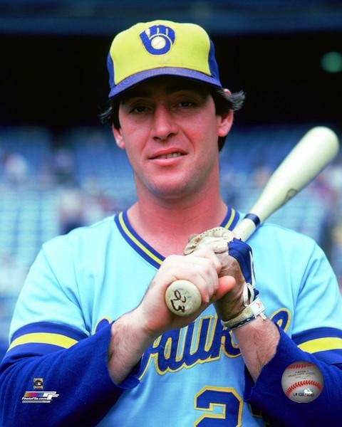 a baseball player holding a bat in his right hand and wearing a catchers mitt