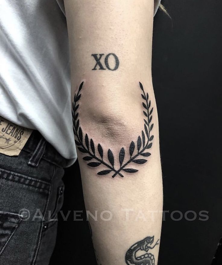 a person with a tattoo on their arm and the word xo written in black ink