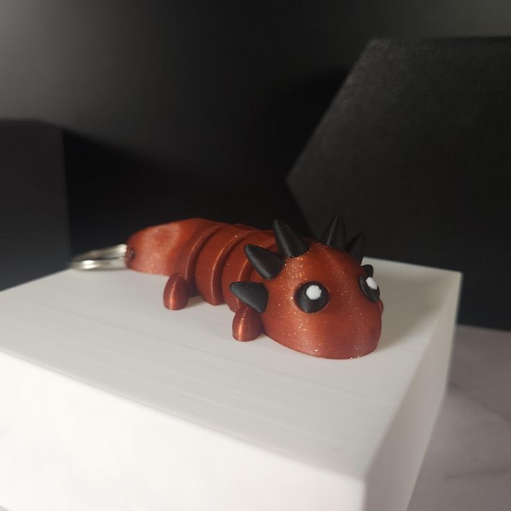 a cake shaped like a dragon sitting on top of a white box with black eyes