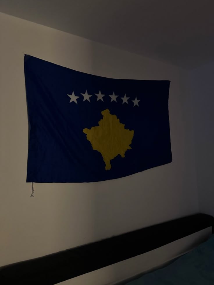 a flag hanging on the wall next to a bed