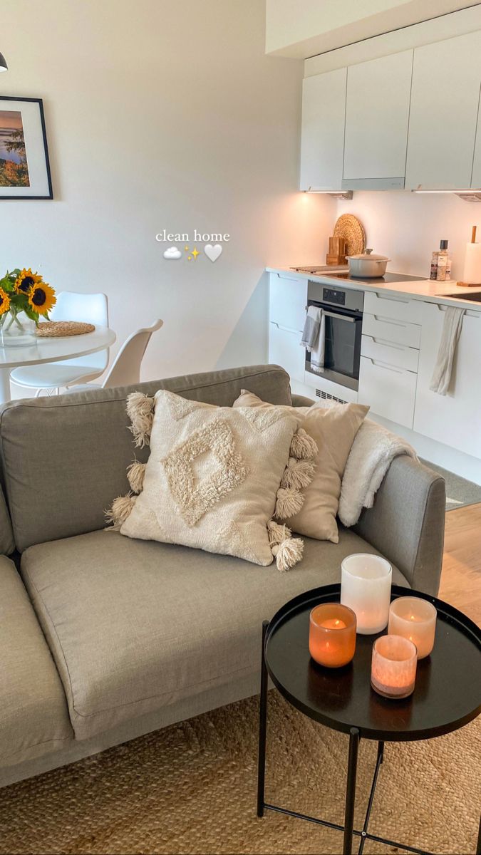 a living room filled with furniture next to a kitchen