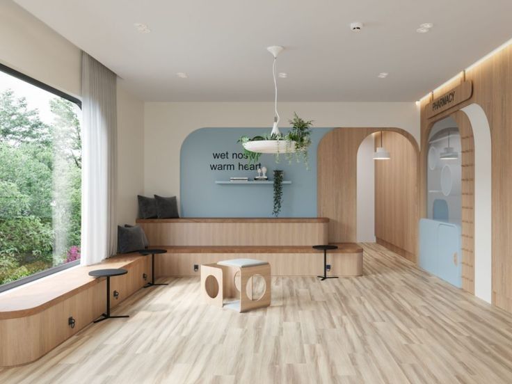 an empty waiting room with wooden floors and large windows