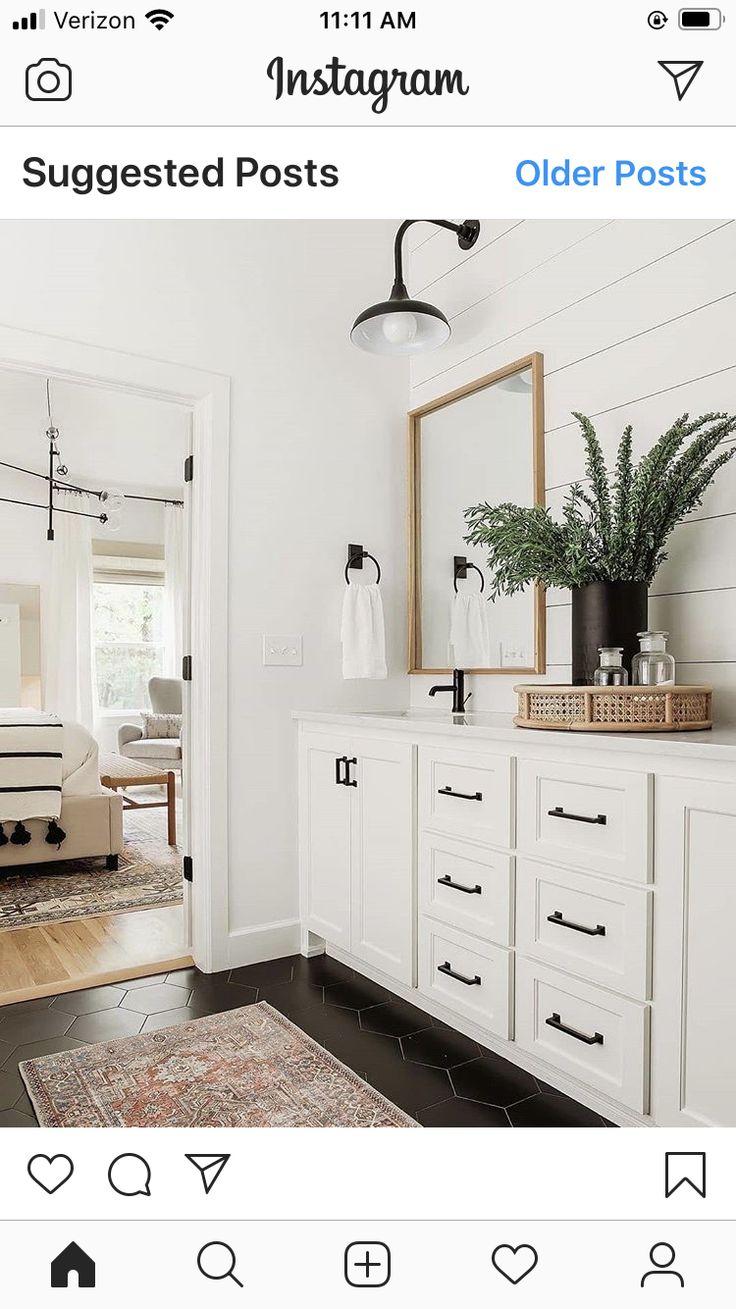 a bathroom with white cabinets and black flooring is seen in this image from the doorway