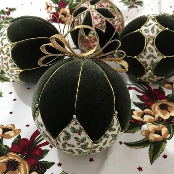 three green and white christmas ornaments on a floral tablecloth with gold trimmings