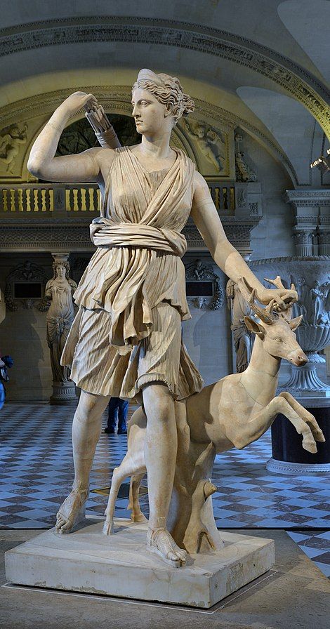 a statue of a woman with a deer in front of her