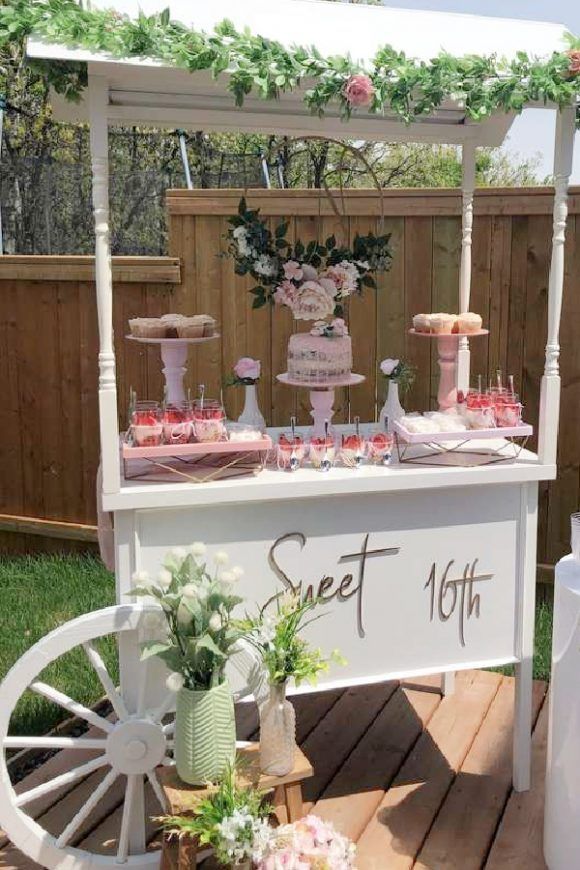 an outdoor dessert table with pink and white decorations