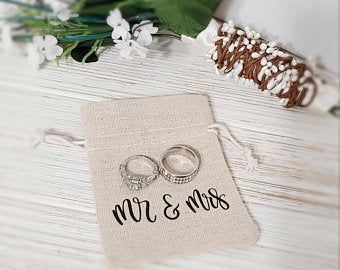 two wedding rings sitting on top of a piece of paper with the word mr and mrs