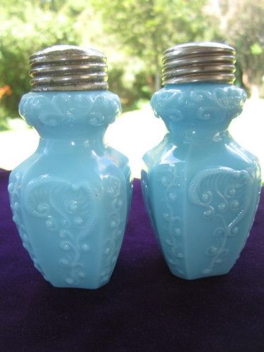 two blue vases sitting on top of a purple cloth