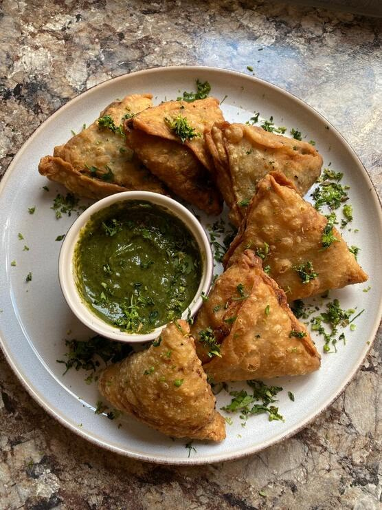 some food is on a white plate with green sauce