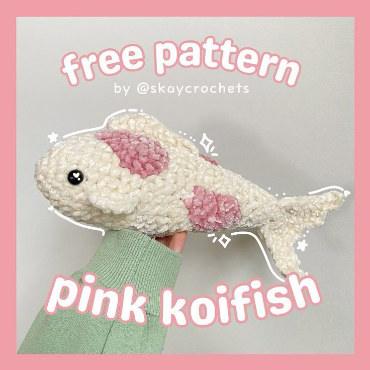 a hand holding a pink koi fish with the words free pattern by skkycrochets