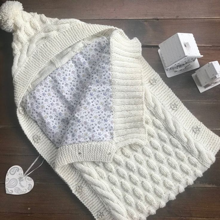 a white knitted blanket and two boxes on a wooden floor