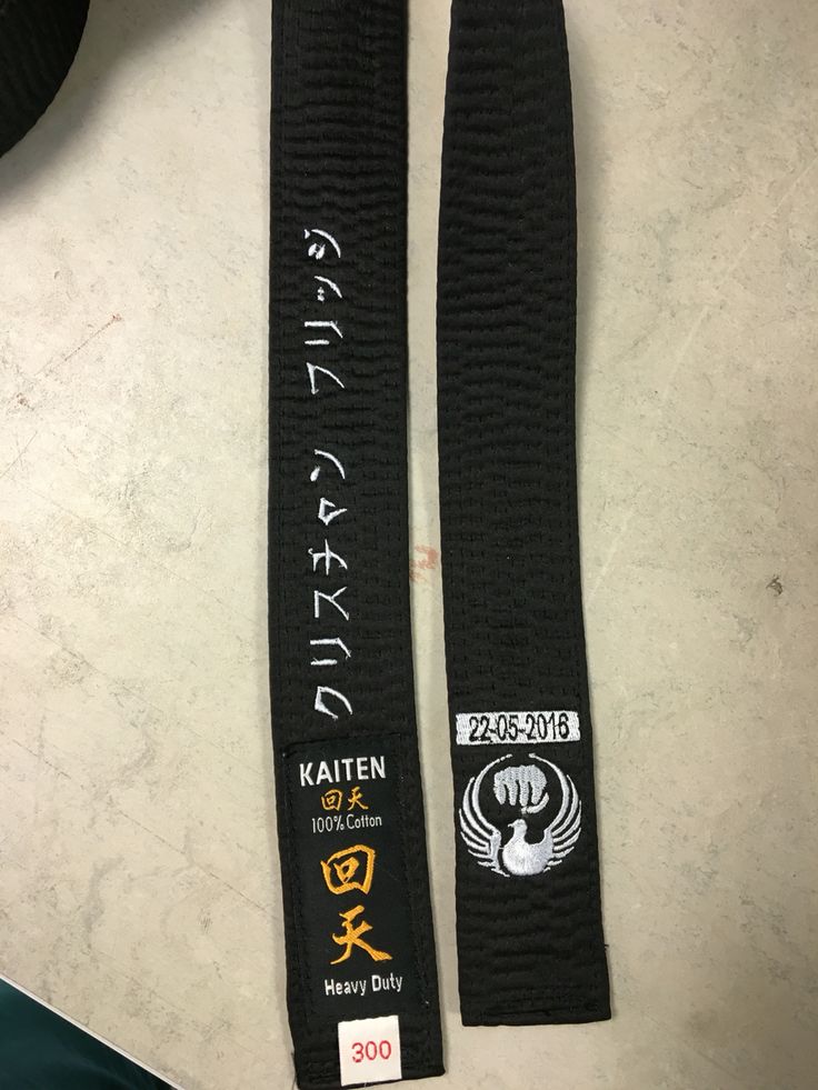 two black karate belts sitting on top of a table