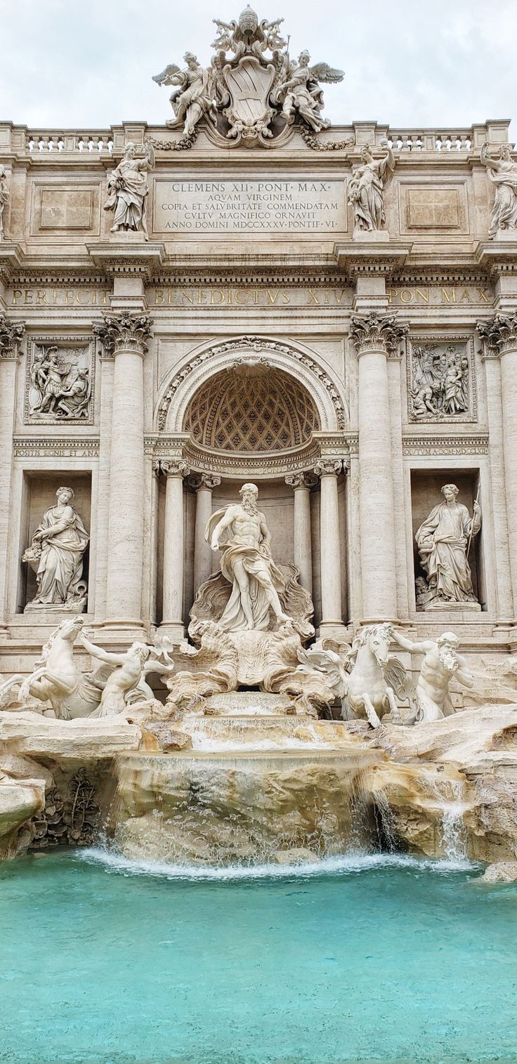 a fountain with statues and water in front of it