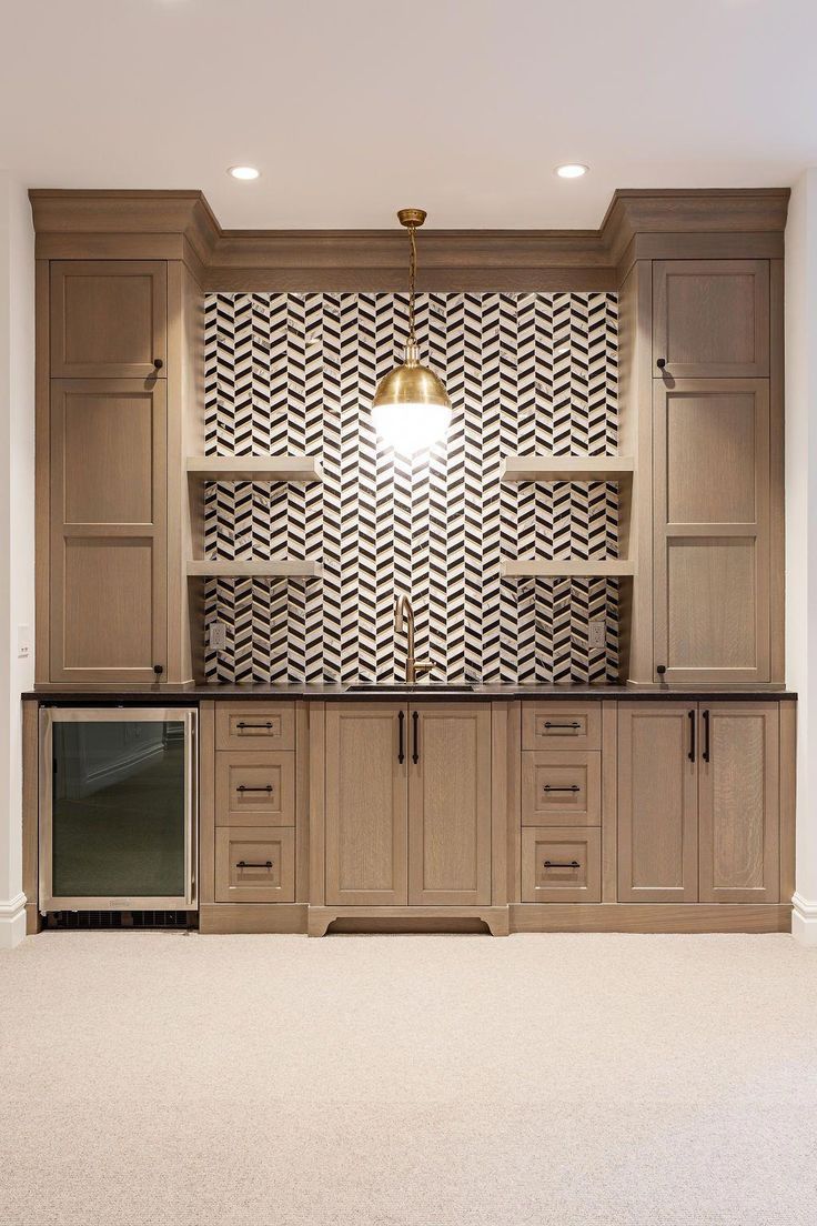 an empty room with white carpet and wooden cabinets