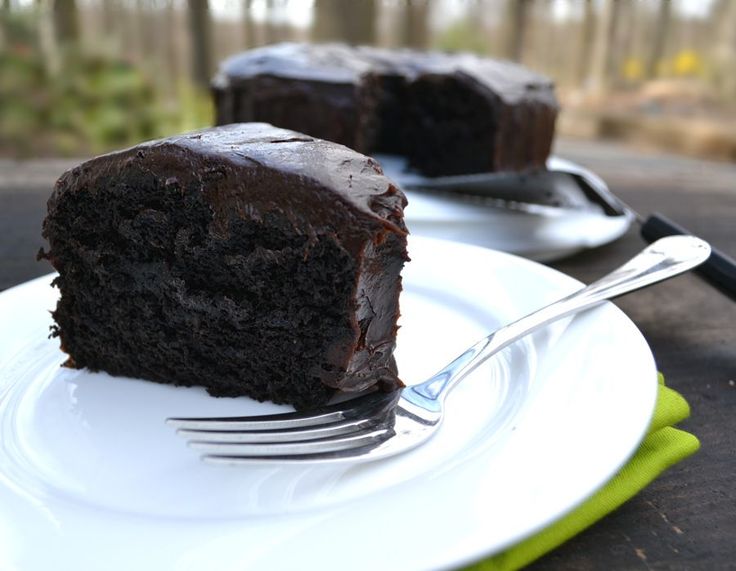 a piece of chocolate cake sitting on top of a white plate next to a fork