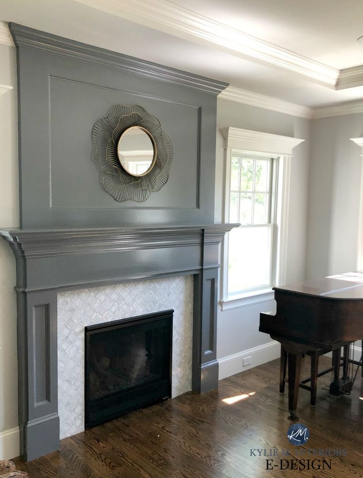 an empty living room with a piano and mirror on the fireplace mantel in front of it