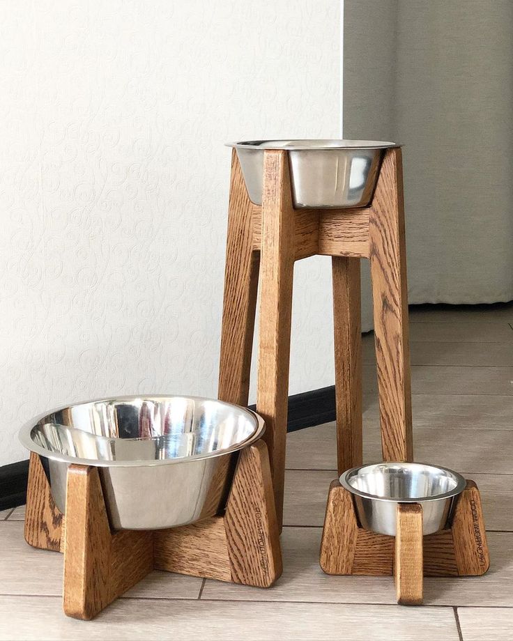 three wooden stands with metal bowls on them