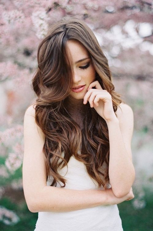 a woman with long brown hair wearing a white dress