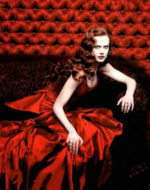 a woman in a red dress is sitting on the ground