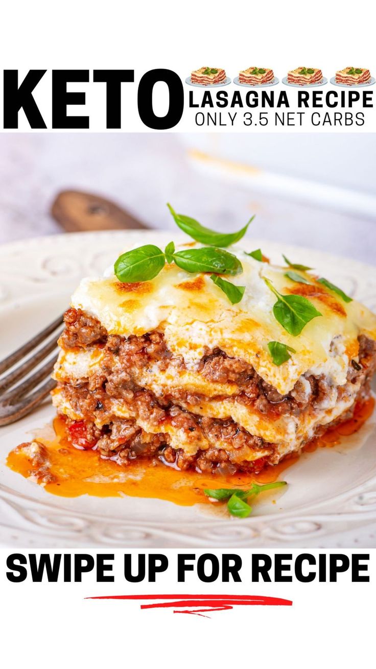 a white plate topped with lasagna covered in cheese and sauce next to a fork