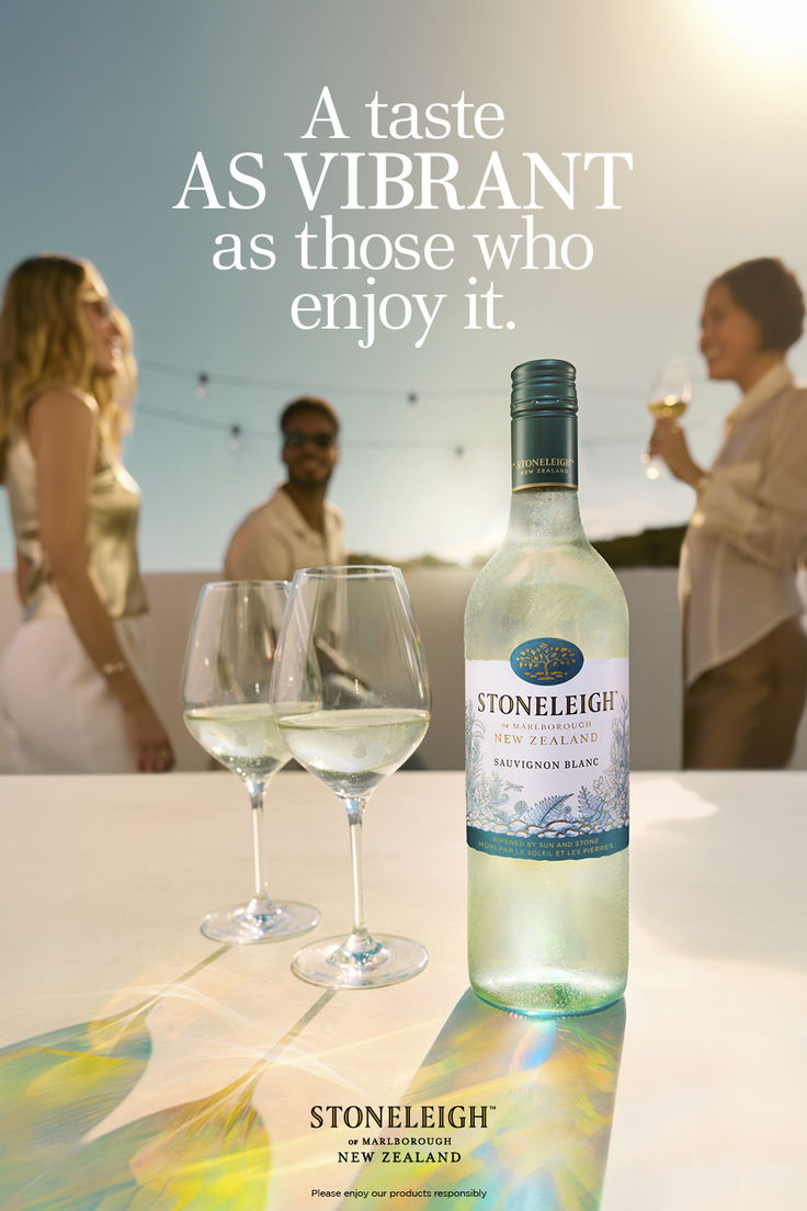 a bottle of wine sitting on top of a table next to two glasses filled with white wine