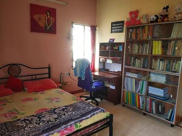 a bedroom with a bed, desk and bookcases