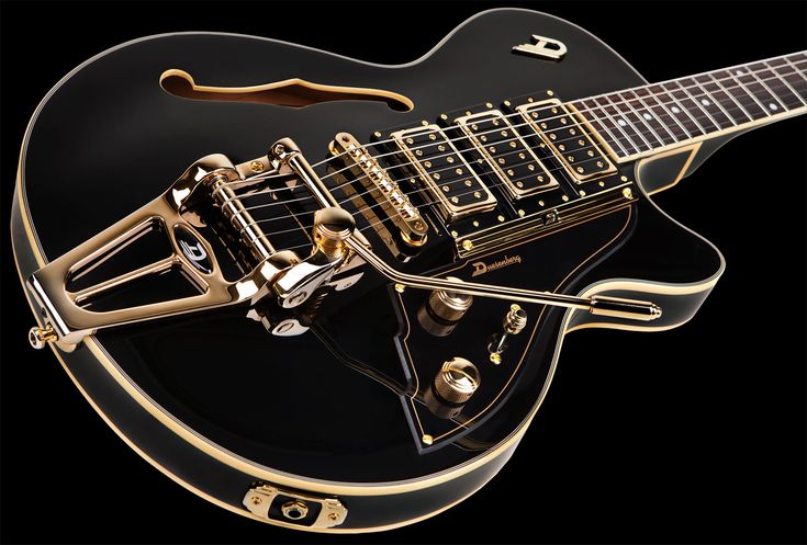 a black and gold electric guitar on a black background