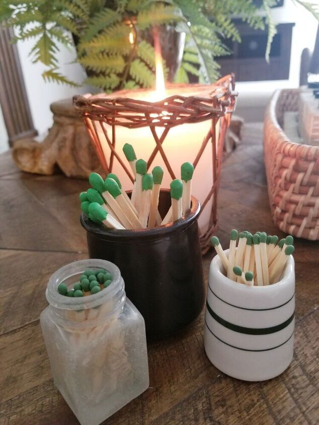 some matches are sitting on a table next to a lit candle and potted plant