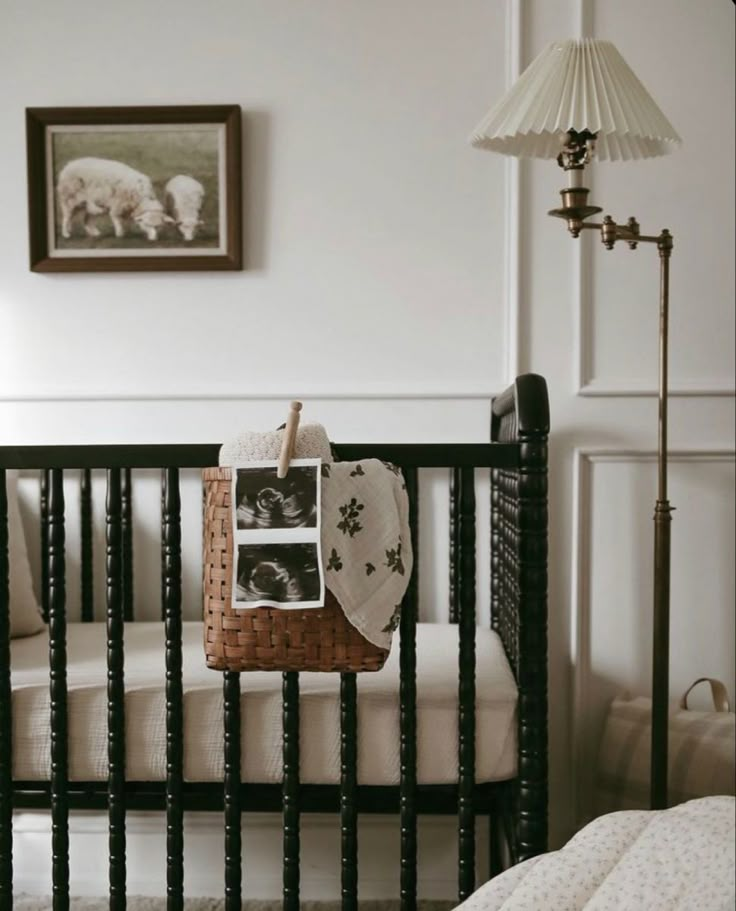 a baby's crib in a white room with sheep pictures on the wall