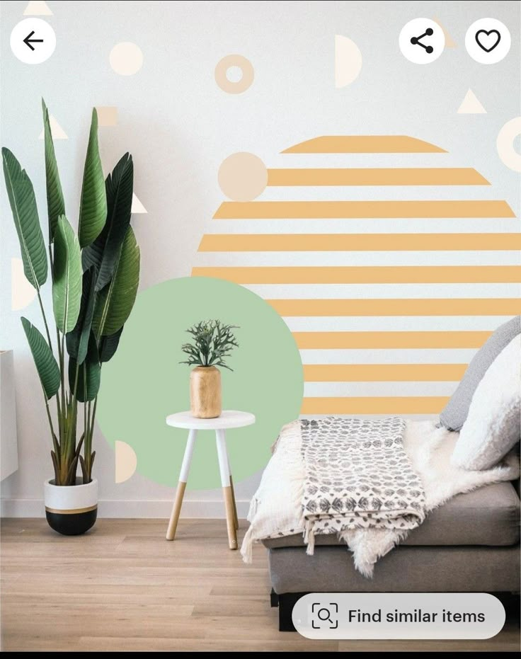 a living room with a couch, potted plant and wall decals on the walls