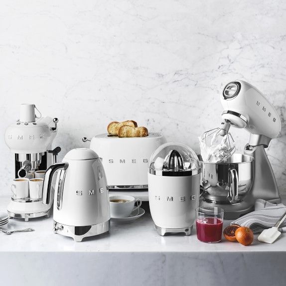 an assortment of kitchen appliances sitting on a counter top next to some fruit and bread