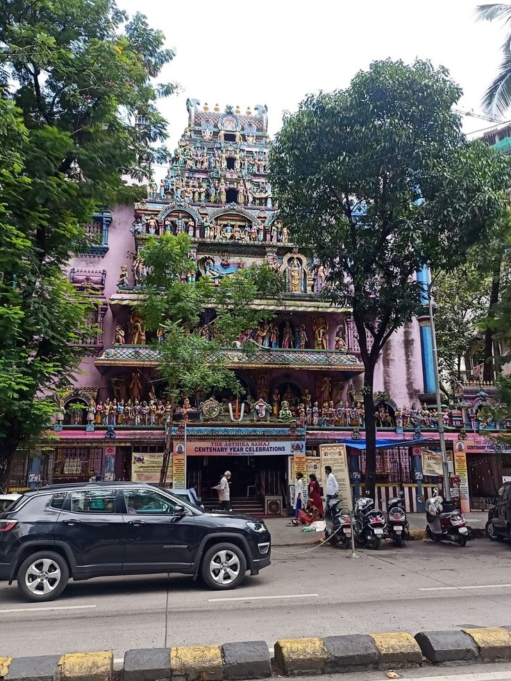 a car parked in front of a building with lots of decorations on the side of it