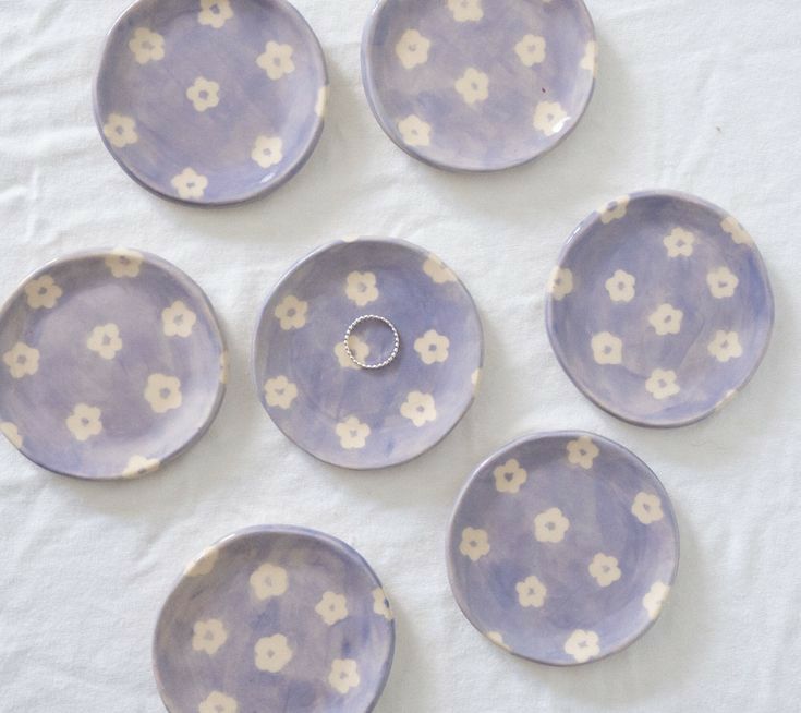 six purple and white plates with flowers on them