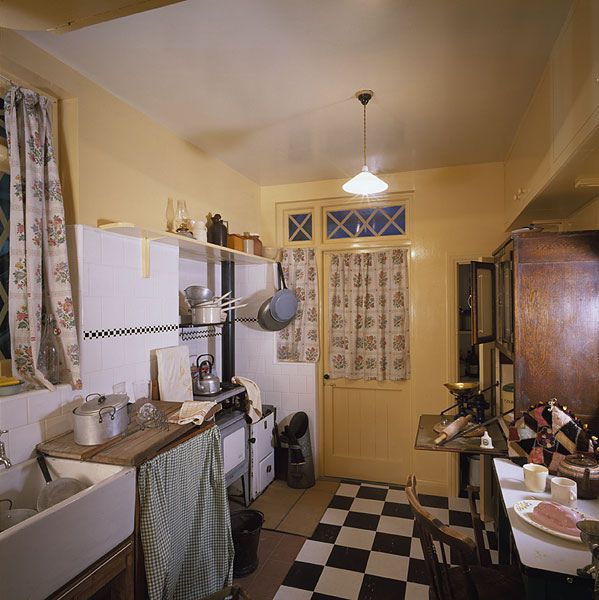 an old fashioned kitchen with checkered flooring and yellow walls is pictured in this image