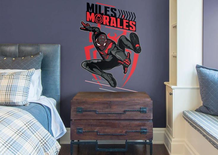 a bedroom scene with focus on the bed and wall decal featuring a spider man